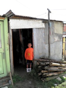Juan Jesus' grandson stands in the doorway of his modest home