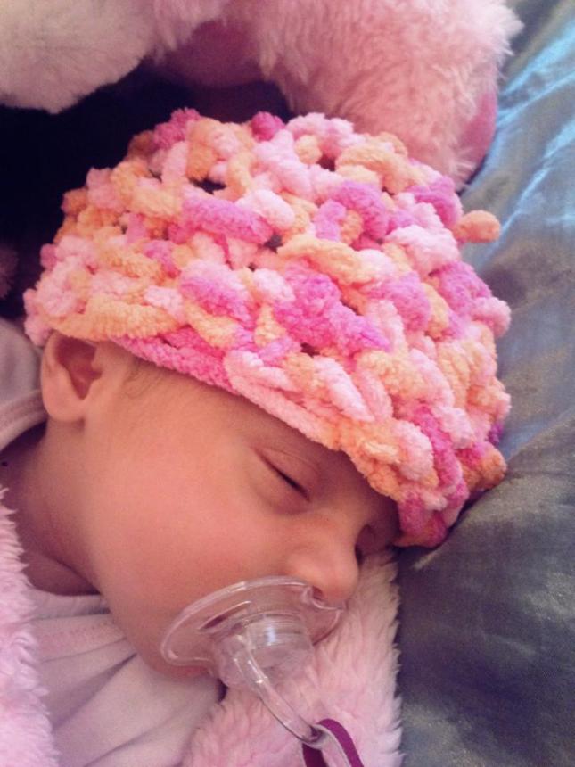 My tiny model wearing the first hat I made